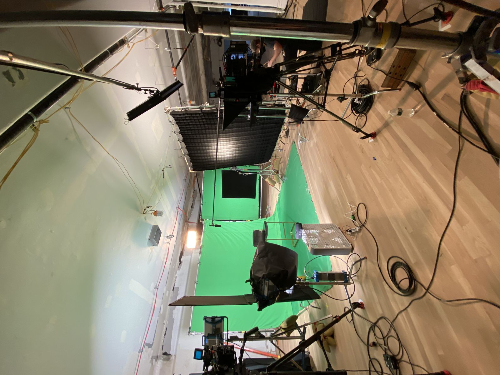 wide of the green screen setup with cameras and lighting