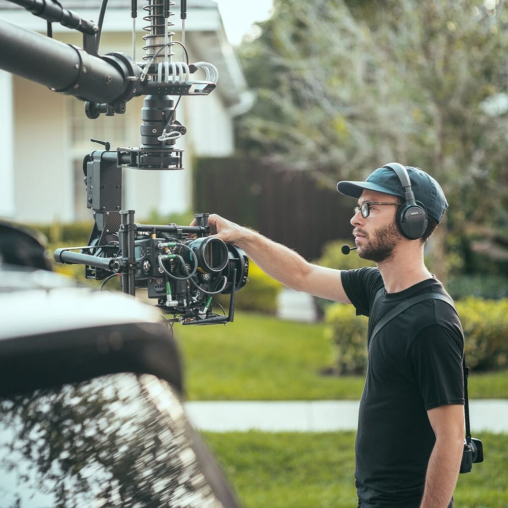 Adam with the MotoCrane on the car, hand on the camera, photo by @iam_motta