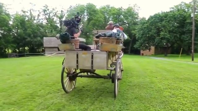 camera operator riding the wagon bed, period actors seated in front